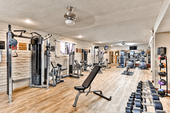 A well-equipped gym with a variety of exercise machines and weights.